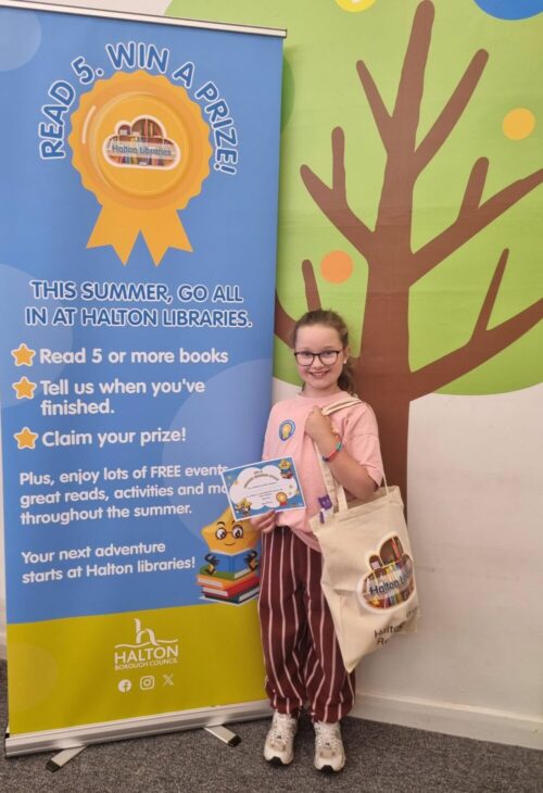 Child smiling with their summer reading challenge prize