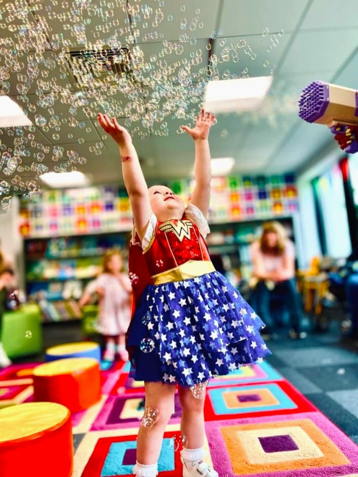 Child playing with bubbles during Rhyme Time